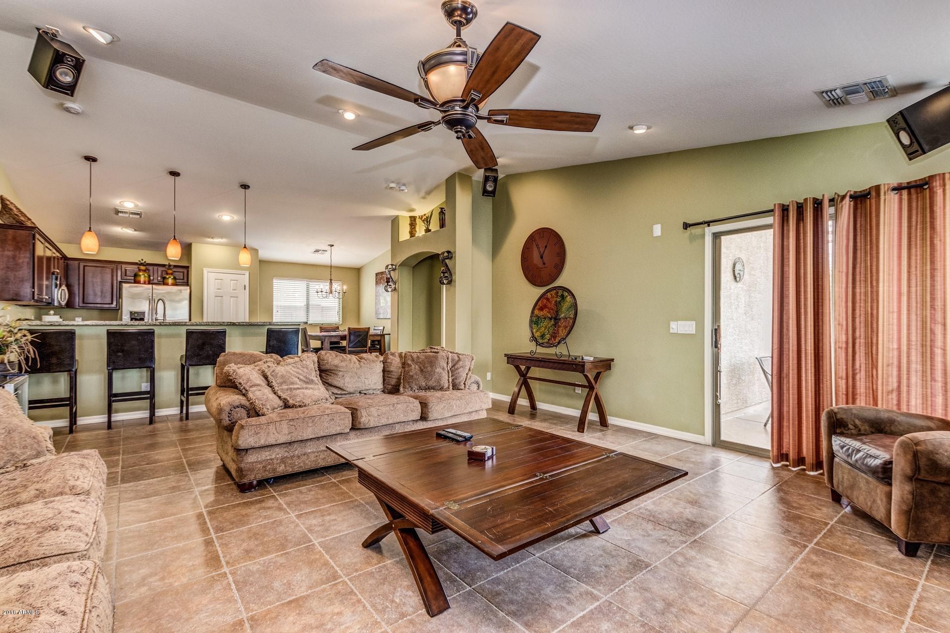 3927 East Blue Sage Road Gilbert, AZ 85297 - Photo 7 of 26 a living room with furniture a clock and a ceiling fan