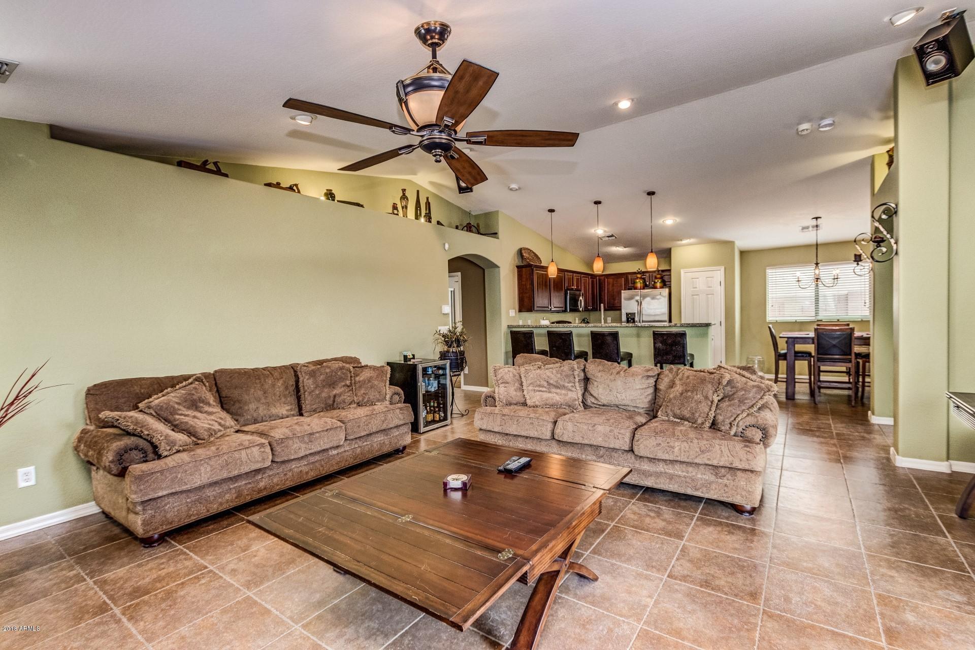 3927 East Blue Sage Road Gilbert, AZ 85297 - Photo 8 of 26 a living room with furniture kitchen view and a chandelier