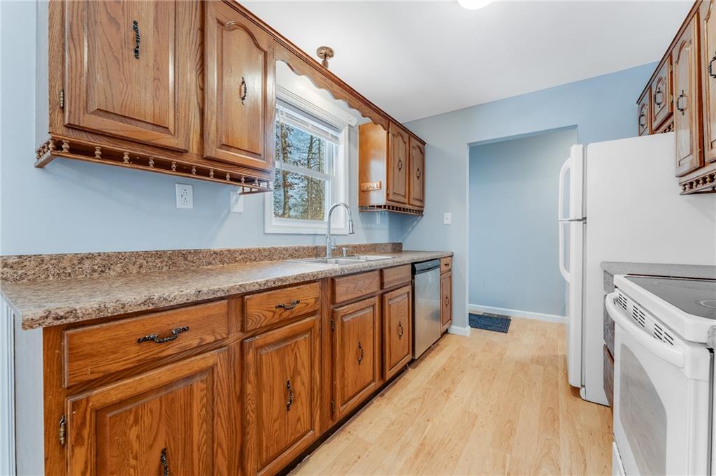 135 Virginia Street Mount Morris, PA 15349 - Photo 25 of 50 a kitchen with stainless steel appliances granite countertop a refrigerator a sink dishwasher and wooden cabinets with wooden floor