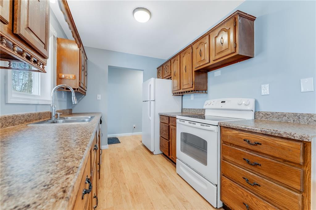 135 Virginia Street Mount Morris, PA 15349 - Photo 26 of 50 a kitchen with granite countertop a sink a stove and cabinets