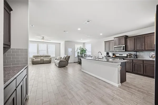 a kitchen with stainless steel appliances granite countertop a sink stove and refrigerator
