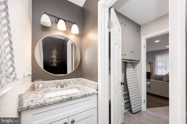 a en suite bathroom with a granite countertop sink and a mirror