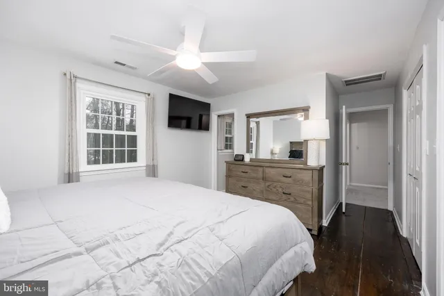 a bedroom with a large bed a flat tv screen and a walk in closet
