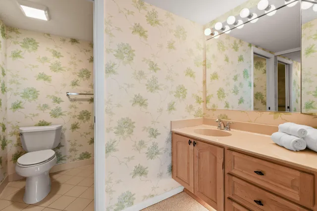 a spacious bathroom with a double vanity sink a large mirror and a shower