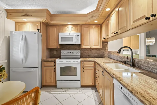 a kitchen with granite countertop a sink stainless steel appliances and cabinets
