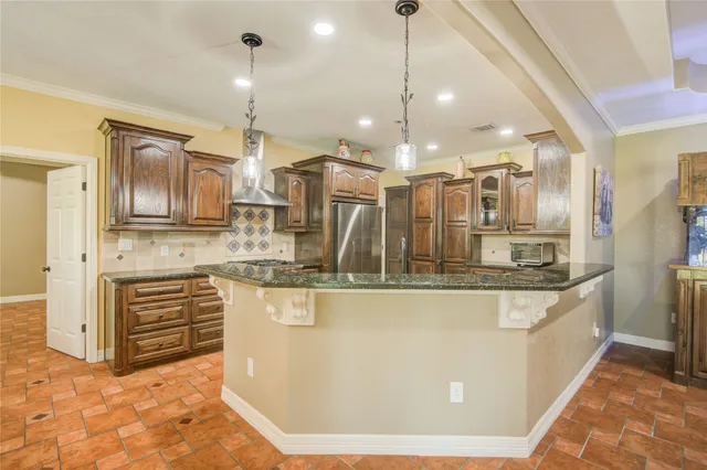 a kitchen with stainless steel appliances granite countertop a sink a stove and a refrigerator
