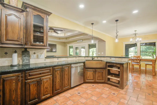 a kitchen with stainless steel appliances granite countertop a stove a sink and a microwave