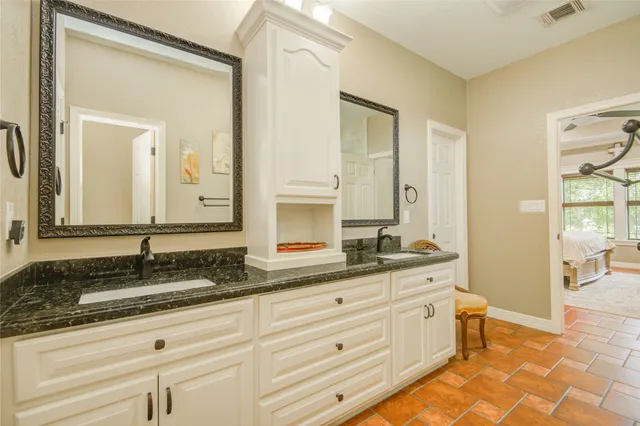 a bathroom with a granite countertop sink and a mirror