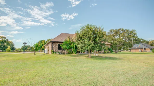 a big yard with table and trees in the background