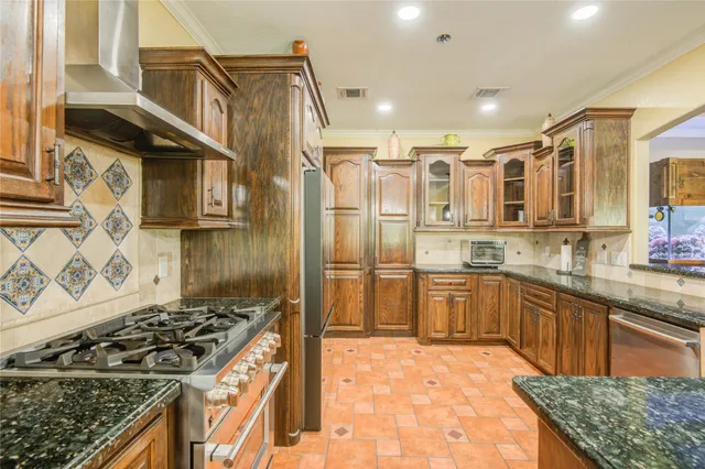 a kitchen with stainless steel appliances granite countertop a stove and a refrigerator