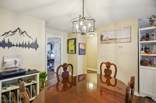 a view of a dining room with furniture a chandelier and wooden floor