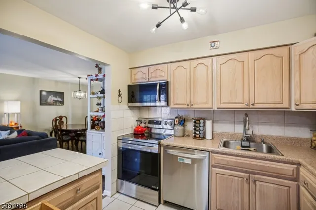 a kitchen with stainless steel appliances a sink stove and white cabinets