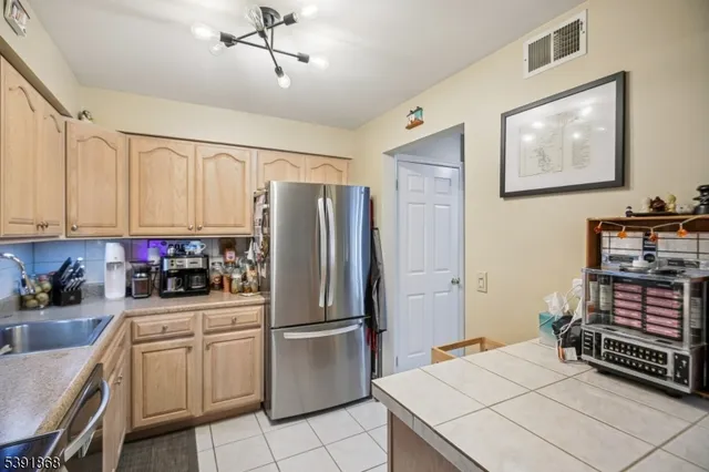 a kitchen with stainless steel appliances a refrigerator sink and cabinets