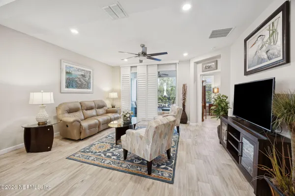 a living room with furniture a flat screen tv and a floor to ceiling window