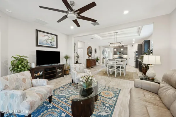a living room with furniture and a flat screen tv with wooden floor
