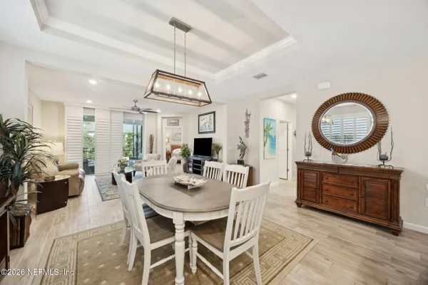 a view of a dining room with furniture a chandelier and wooden floor