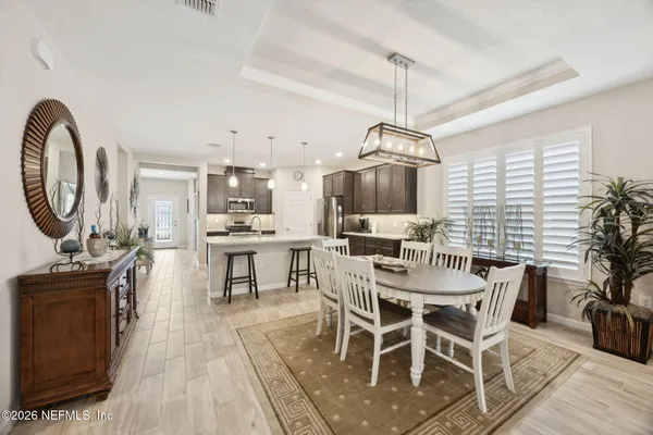 a view of a dining room and livingroom with furniture wooden floor a chandelier