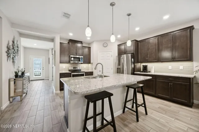 a large kitchen with stainless steel appliances kitchen island granite countertop a sink and cabinets