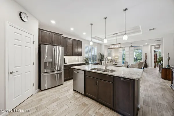 a kitchen with stainless steel appliances granite countertop a sink a stove and a refrigerator