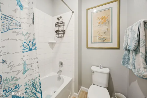 a white toilet sitting next to a bath tub