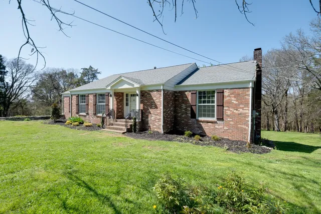 a view of a house with backyard sitting area and garden