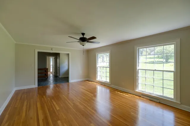a kitchen with granite countertop appliances cabinets wooden floor and a window