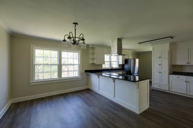a large kitchen with stainless steel appliances granite countertop a stove and a sink