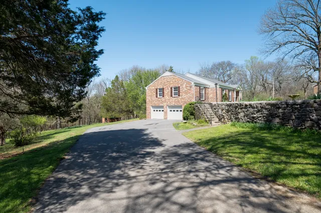 a front view of a house with yard and green space