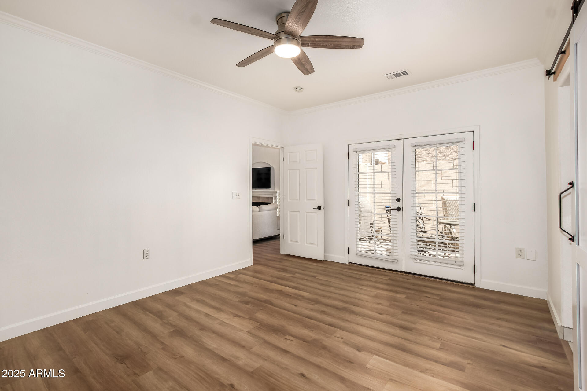 3221 North 37th Street, Unit 4 Phoenix, AZ 85018 - Photo 21 of 40 a view of an empty room with wooden floor and a ceiling fan