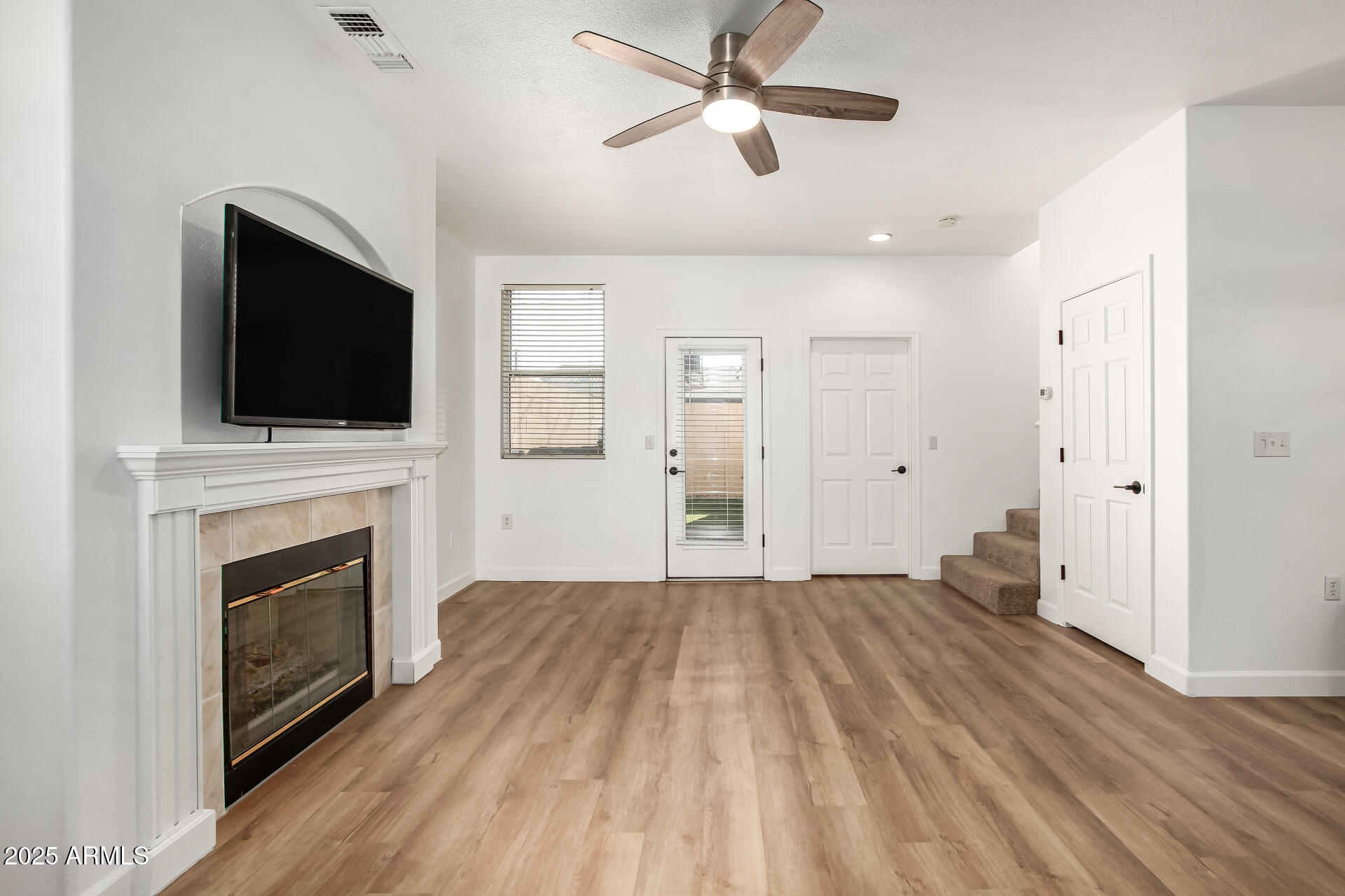 3221 North 37th Street, Unit 4 Phoenix, AZ 85018 - Photo 6 of 40 a view of a livingroom with a fireplace a ceiling fan a kitchen stove and a window