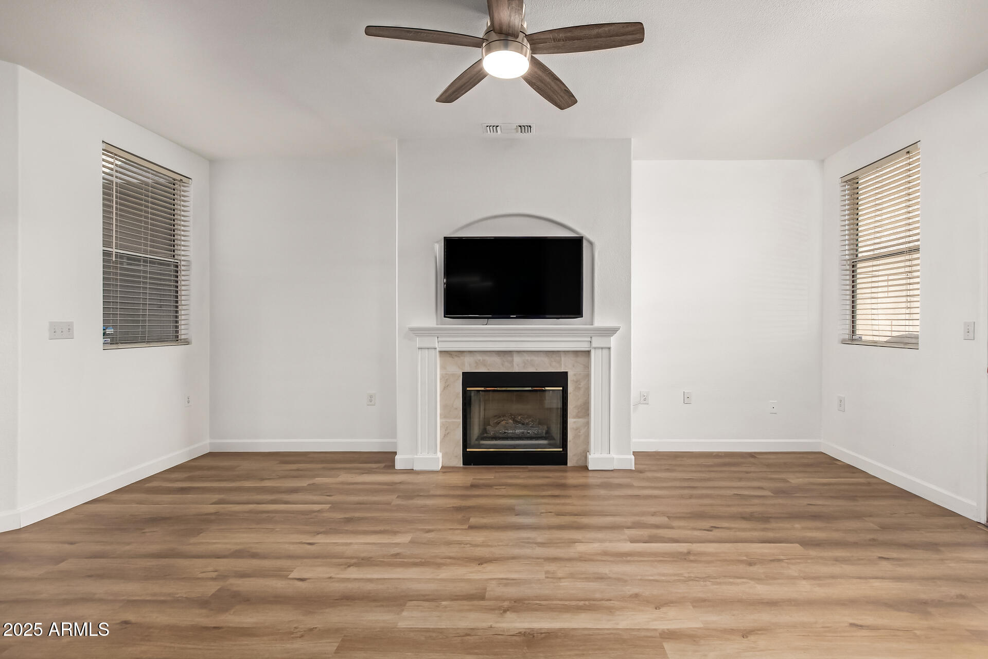 3221 North 37th Street, Unit 4 Phoenix, AZ 85018 - Photo 7 of 40 a view of empty room with wooden floor fireplace and fan