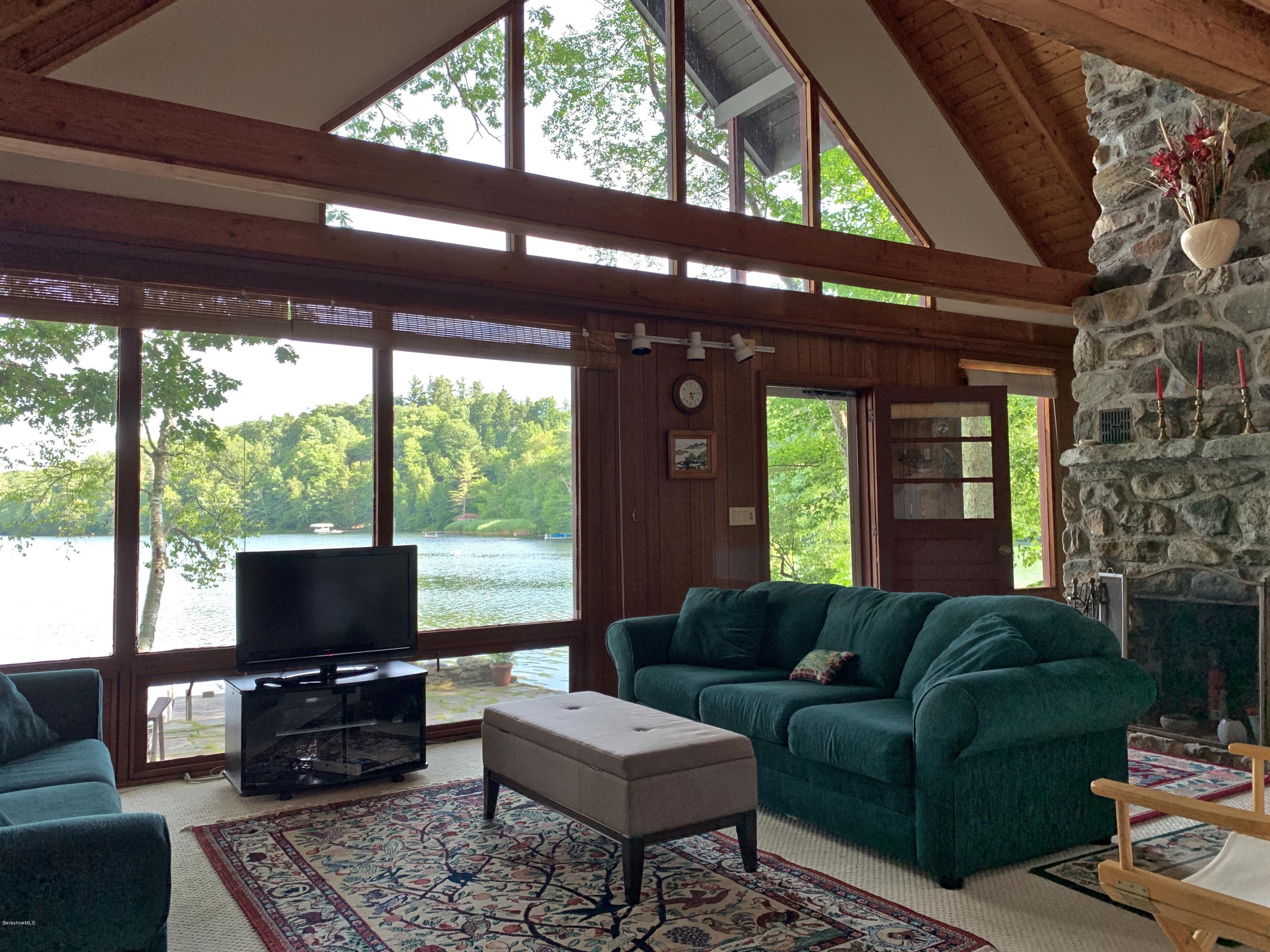 23 Point Road Monterey, MA 01245 - Photo 5 of 24 a living room with furniture a flat screen tv and a floor to ceiling window