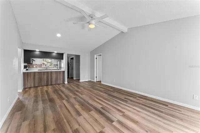 a view of an empty room with a kitchen