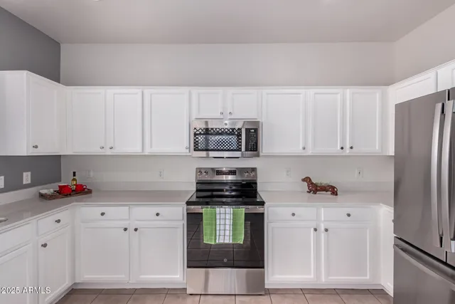 a kitchen with white cabinets and white appliances