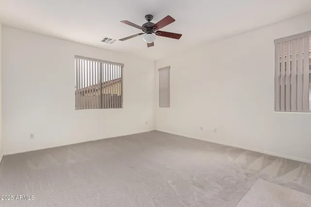an empty room with a window and a ceiling fan