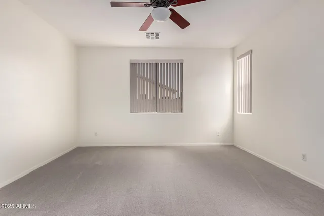 an empty room with a window and a ceiling fan