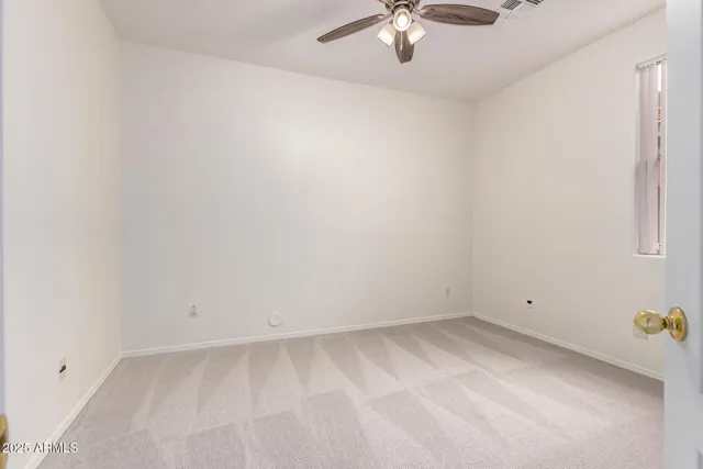 an empty room with chandelier fan
