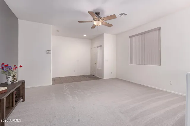 an empty room with a ceiling fan and window