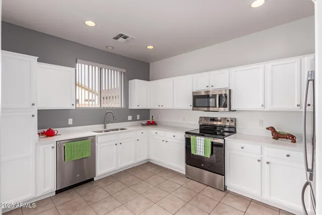 a kitchen with a sink window and white stainless steel appliances