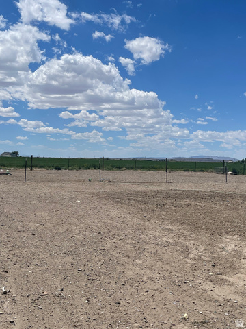 289 West Center Street Hinckley, UT 84635 - Photo 13 of 13 Expansive parcel featuring a cleared, level dirt surface, partial fencing, and distant green fields