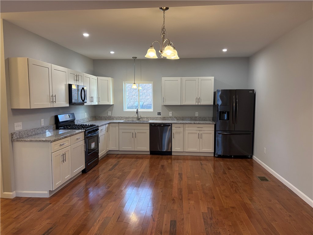 184 Avenue C, Unit E5 Woonsocket, RI 02895 - Photo 2 of 11 Beautiful kitchen featuring granite countertops and black stainless steel appliances.