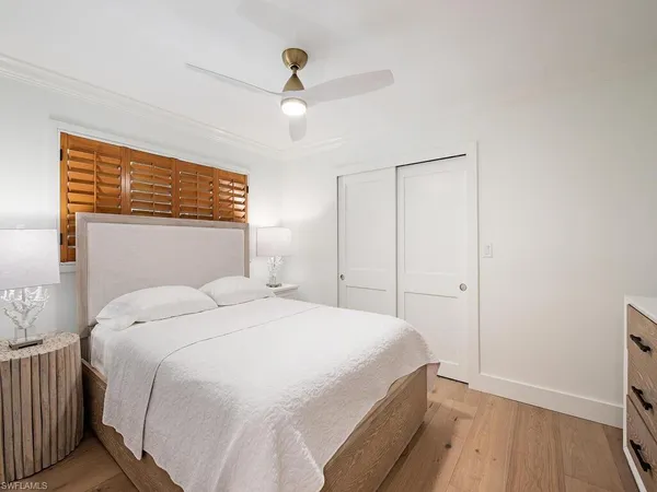 a bedroom with a bed and a ceiling fan