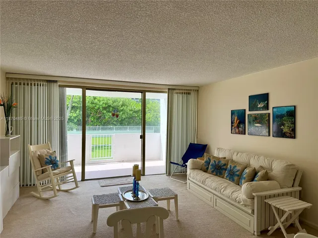 a living room with furniture and floor to ceiling windows