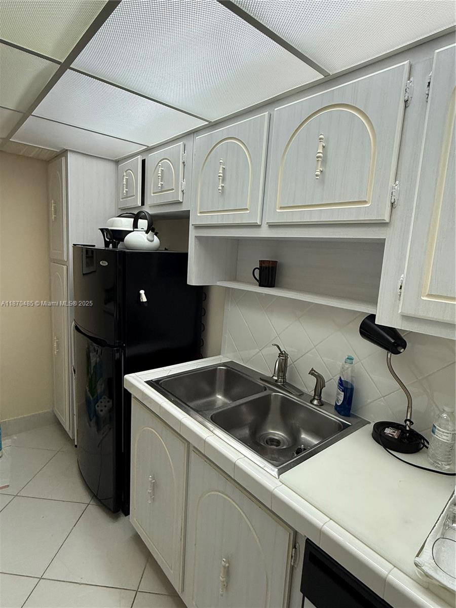 199 Ocean Ln Drive, Unit 203 Key Biscayne, FL 33149 - Photo 9 of 17 a kitchen with white cabinets and a sink