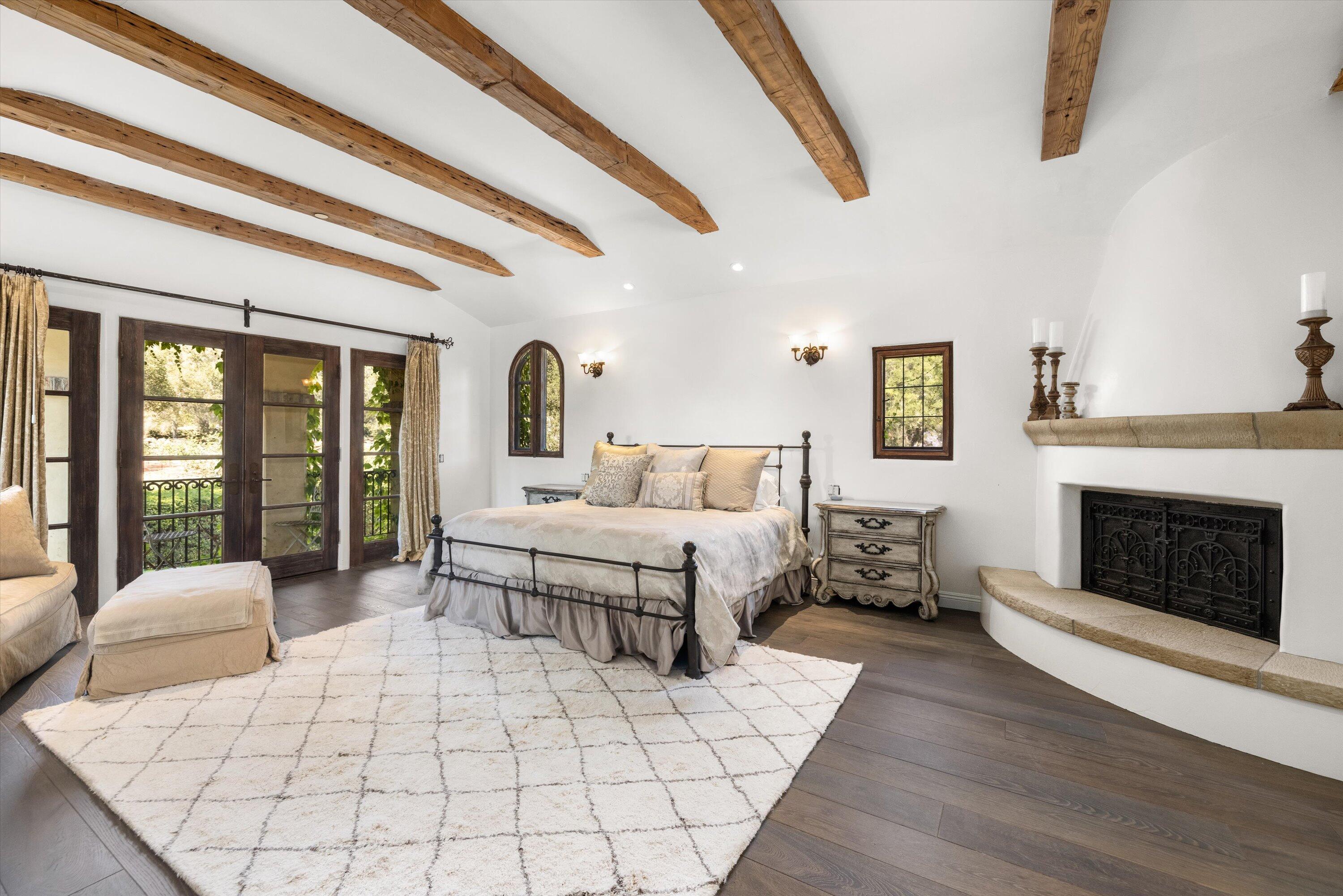 2222 East Valley Road Montecito, CA 93108 - Photo 16 of 30 a bedroom with a large bed and a fireplace