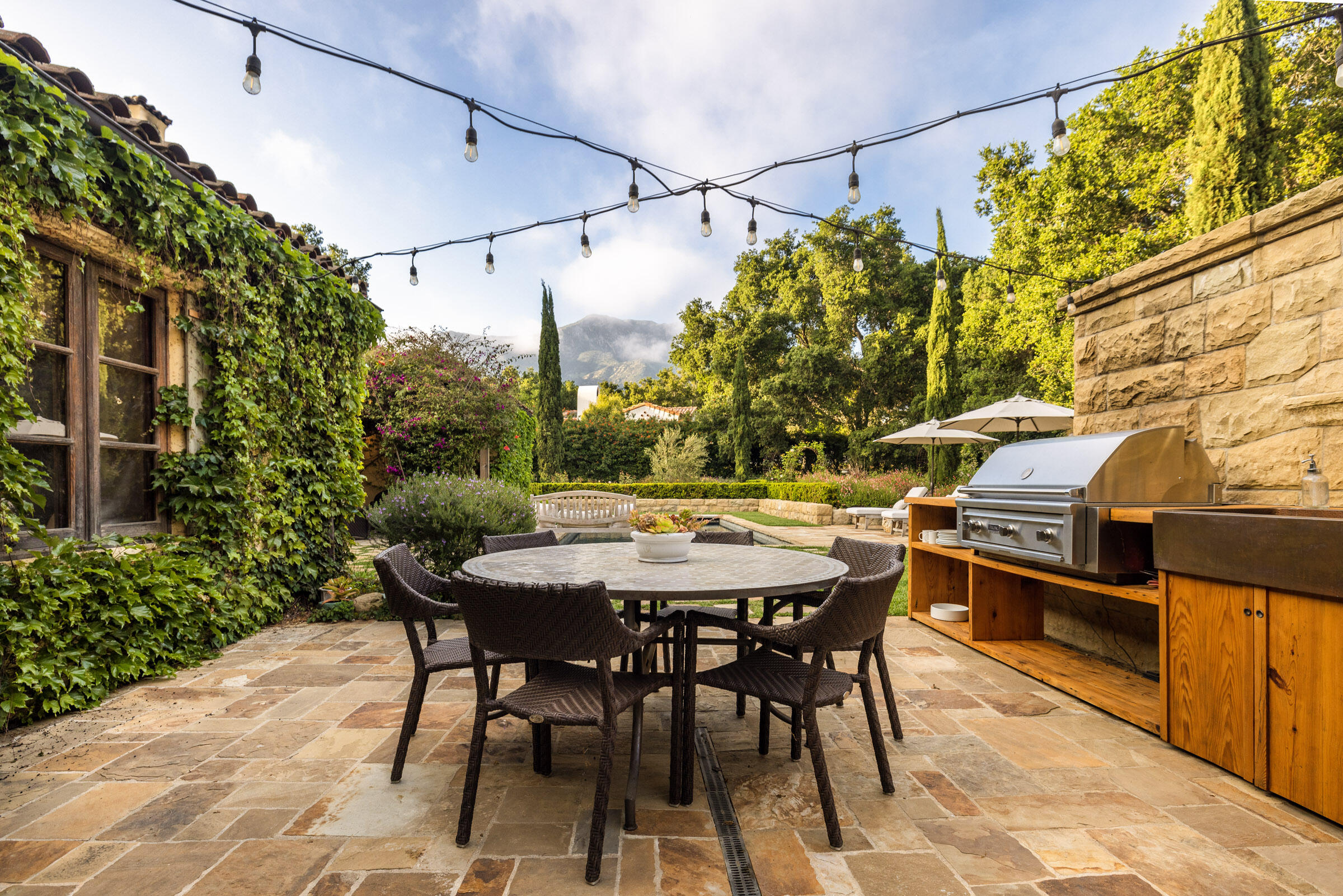2222 East Valley Road Montecito, CA 93108 - Photo 22 of 30 a view of a patio with table and chairs and potted plants