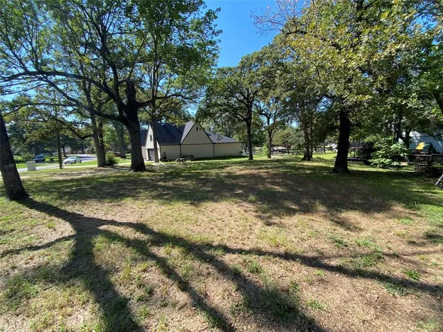 a view of a yard with large trees
