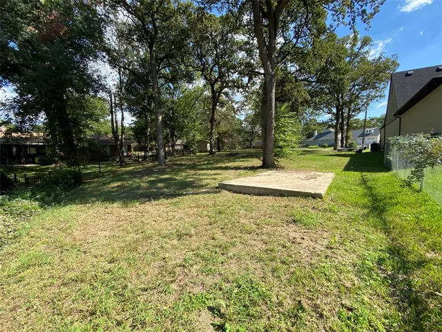 a view of a backyard with large trees