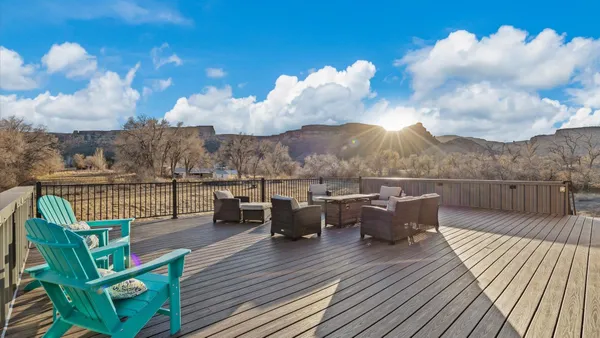 a view of a patio with dining table and chairs with wooden floor