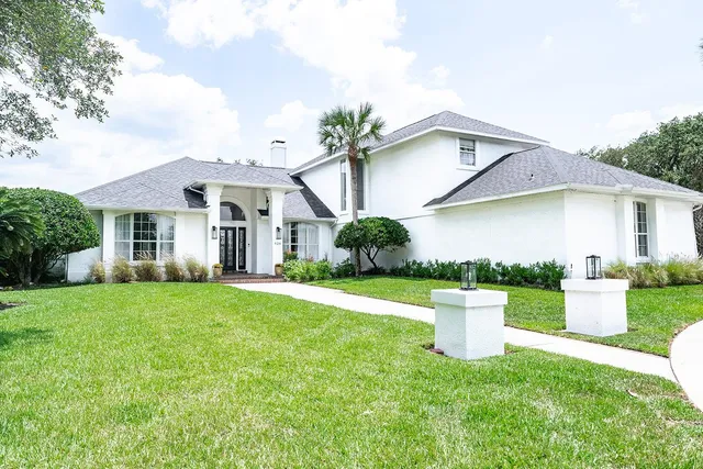 a front view of a house with a yard and trees